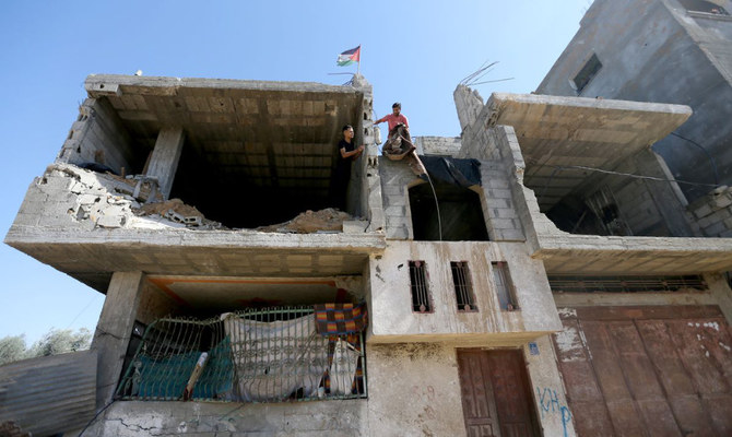 昨年5月のガザ紛争でイスラエルの空爆により破壊された家で働くパレスチナ人。2021年9月26日、ガザ地区南部のハーン・ユーニスにて。(ロイター)