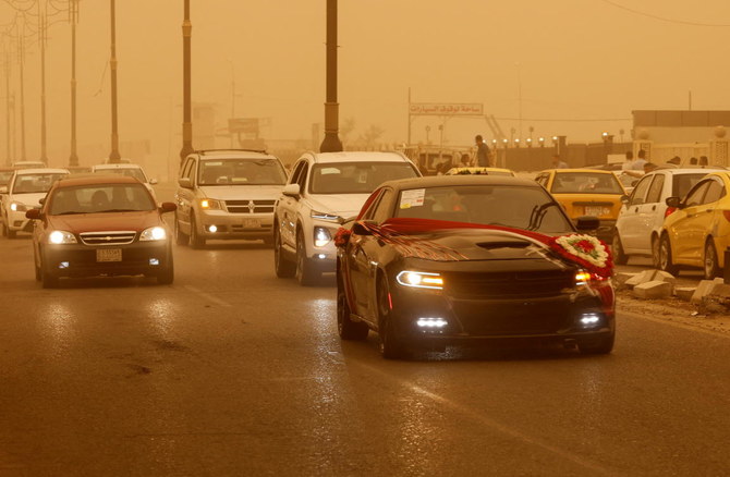 砂嵐の中を走るウェデイングカー。2022年5月23日、イラクのモスル。（ロイター）