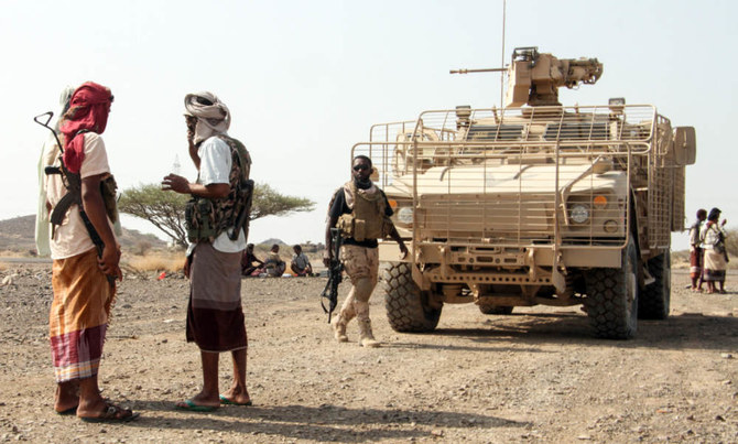  中心都市タイズ北西の山岳地帯のフーシ派から奪取した拠点で、装甲車の傍に立つイエメン政府軍兵士たち。（AFP）