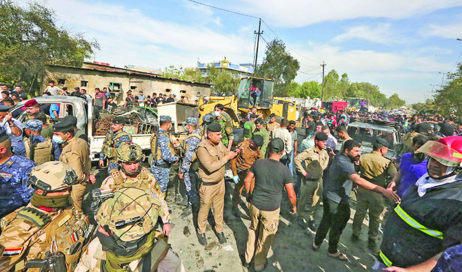 昨年バグダッドでダーイシュのテロリストが実行し、死者を出した爆発事件の現場に集まるイラク軍と治安部隊の隊員たち。（AFP通信）