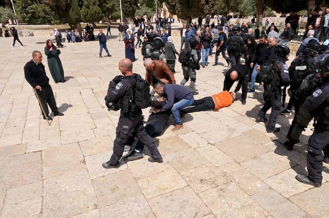 2022年5月5日、イスラエル治安部隊とパレスチナ人の衝突の中、男性が2人地面に倒れている。（AFP）