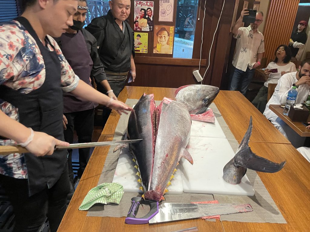 クロマグロは食事客たちの目の前の大きなまな板の上に置かれ、それを料理長が、指定された複数の包丁を使って巧みに切り分けた。（ANJ写真）