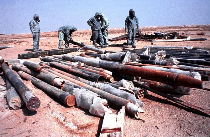 イラクの武装解除を担当する国連特別委員会（UNSCOM）査察官が、イラクの砂漠（場所は特定されていない）で、化学神経剤サリンが充填されたイラクのロケットを破壊する準備をしている。（UNSCOM/AFP）
