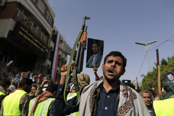 フーシ派の戦闘員が、サヌアで開かれた集会で武器を誇示し、彼らの指導者であるアブデルマリク・アル・フーシの肖像画を掲げている。（2022年6月3日撮影）（AFP）