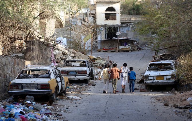 フーシ派に包囲されたイエメン第3の都市タイズ市で、損傷した車の傍を歩く子供たち。（File/AFP）
