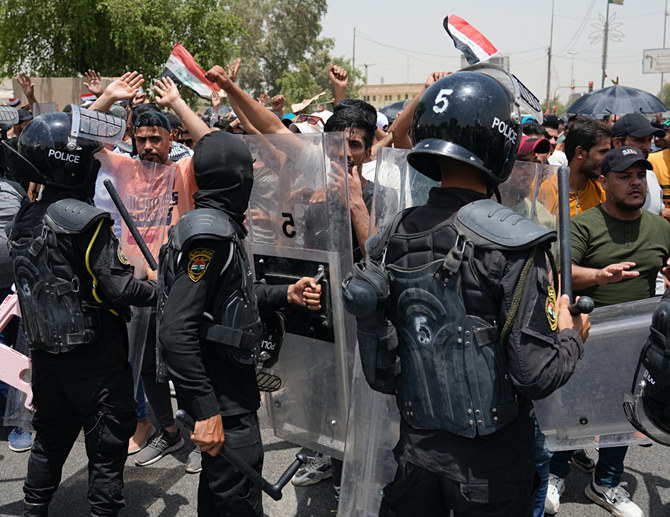 2022年6月7日、バグダッドのイラク議会付近でデモ隊がスローガンを唱える中、警備隊が警備に当たる。(AP写真/ハディ・ミズバン)