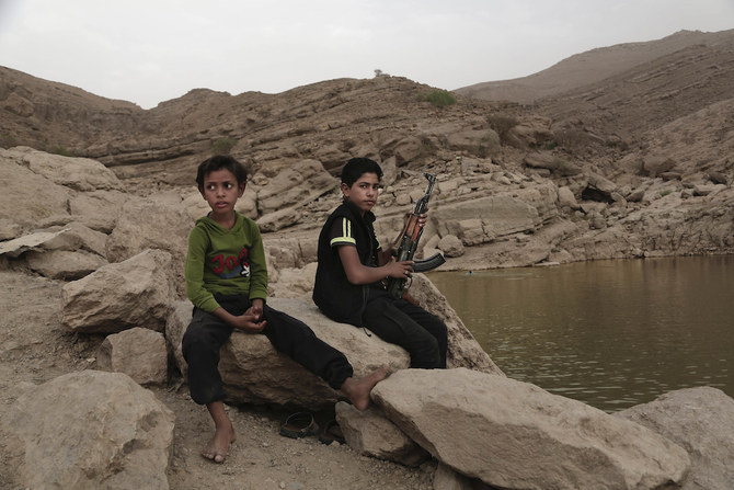 2018年7月30日、イエメンのマアリブにあるハイ・ダムで、17歳の少年が武器を手にしている。（AP）