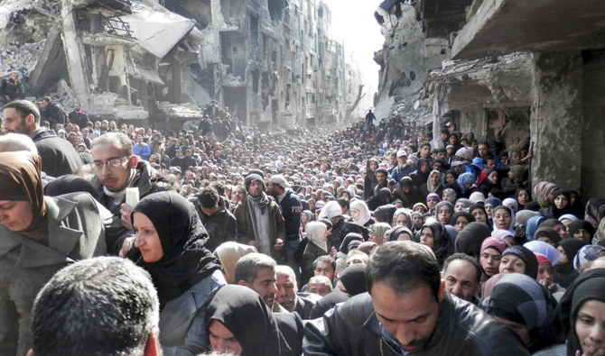 シリアのダマスカスで、包囲されているヤルムーク・パレスチナ難民キャンプの住民が、食糧の供給を受けるために並んでいる。（AP）