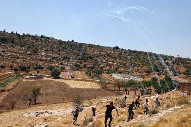 占領下のヨルダン川西岸地区の入植地エリで、イスラエル入植者たちの企てに抗議するパレスチナ人たちがイスラエルの催涙ガスから逃げている。（AFP）