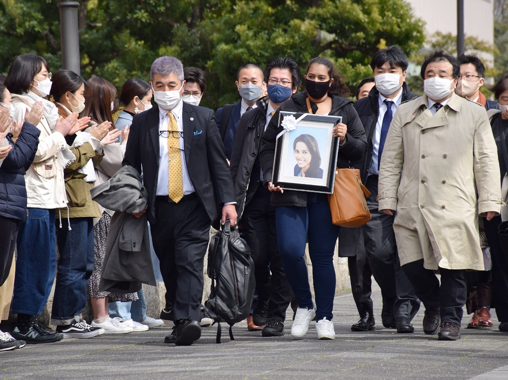 2022年3月4日、日本の入国管理局で1年前に死亡したスリランカ人女性ウィシュマ・サンダマリさんの妹が亡くなった姉の写真を持ち、日本政府を提訴する為に名古屋地裁へ向かう。(AFP/ファイル写真) 