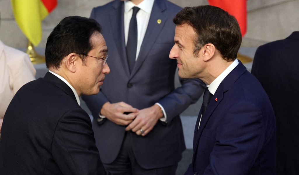 2022年3月24日、ブリュッセルで開かれるG7首脳会合の前に、日本の岸田文雄首相（左）とフランスのエマニュエル・マクロン大統領が握手している。（AFP）
