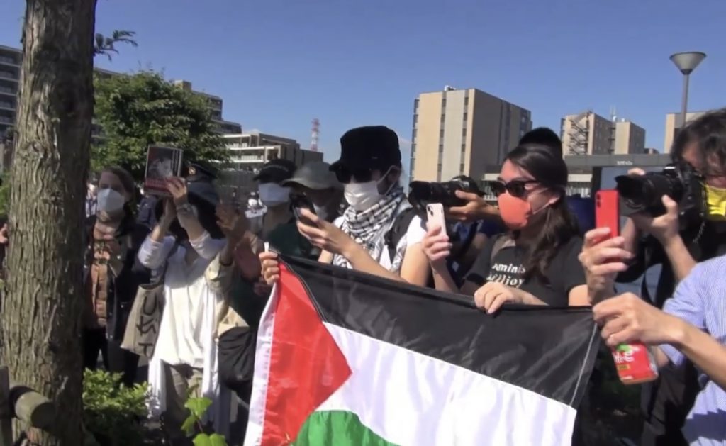 重信氏の出所を待つ間、パレスチナの旗を掲げる重信氏の支持者たち。（2022年5月28日、東京都内で）（ANJP写真）