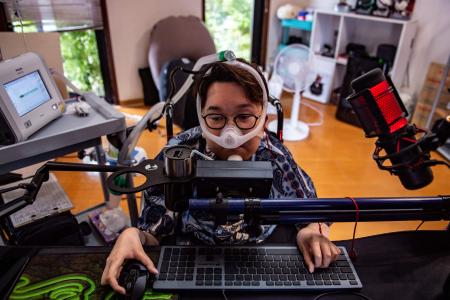 岩手県紫波町の自宅でビデオゲームの練習をするeParaの畠山駿也氏。2022年7月撮影。(AFP)