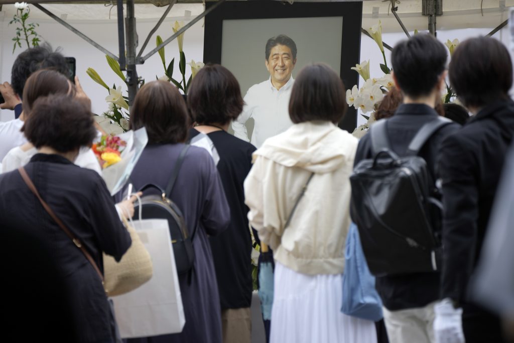2022年7月12日火曜日、東京都の増上寺で、安倍晋三元首相の葬儀の前に、人々が花と祈りをささげるために列を作っている（資料写真/AP）
