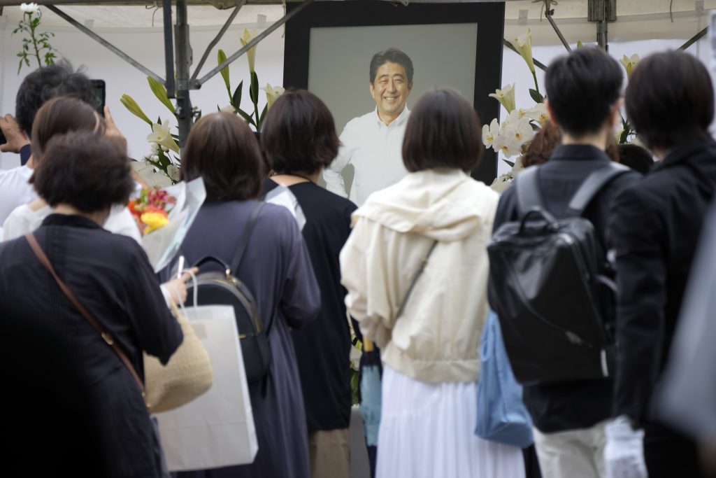 2022年7月12日火曜日、東京都の増上寺で、安倍晋三元首相の葬儀の前に、人々が花と祈りをささげるために列を作っている(資料写真/AP)