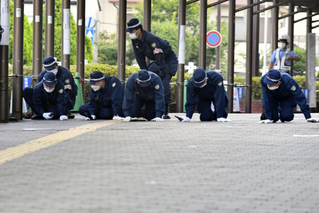 安倍晋三元首相が射殺された現場近くの歩道を調査する警察官＝2022年7月13日、西日本・奈良県（File phoyo/Kyodo News via AP）