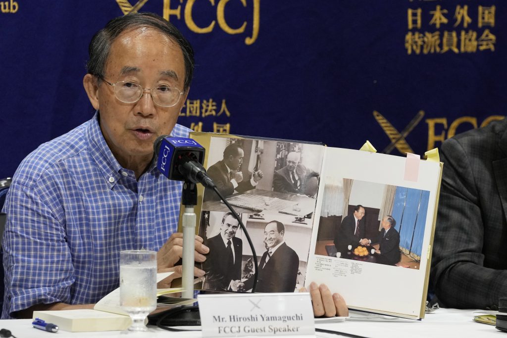 旧統一教会とその活動に関する記者会見で、教会の関連書籍を手に話す山口広弁護士（2022年7月29日、東京・日本外国特派員協会で）。（写真：AP）