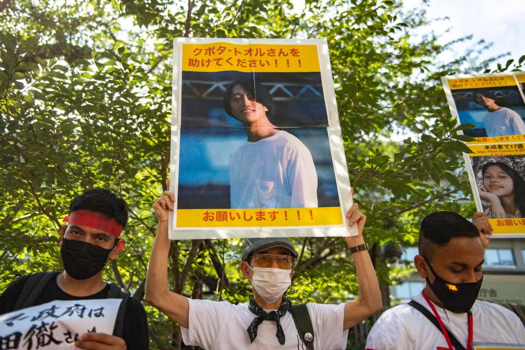 東京の外務省前での集会で、ミャンマーで拘束されている日本人・久保田徹氏の写真を掲げる人々（2022年7月31日）。（資料写真/AFP）