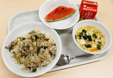 東京・千寿青葉中学校の、玉ねぎ塩豚丼、スープ、パックの牛乳、スイカなどの給食。=2022年6月29日、東京都千代田区。(ロイター)
