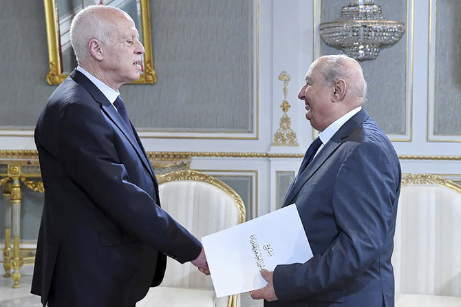チュニスのカルタゴ宮殿で、カイス・サイード大統領(左)に新憲法草案を提出するチュニジア新憲法起草委員会のサドク・ベライド委員長。(AFPファイル写真)