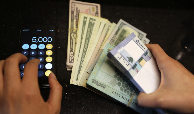 外貨両替店でレバノンポンドと米ドル紙幣を数える女性。レバノンのベイルート。(ロイター)