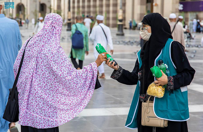 メディナ当局のボランティアは、「預言者のモスク」への訪問者に対し、日差しから守るため傘の配布を続けている。(SPA)
