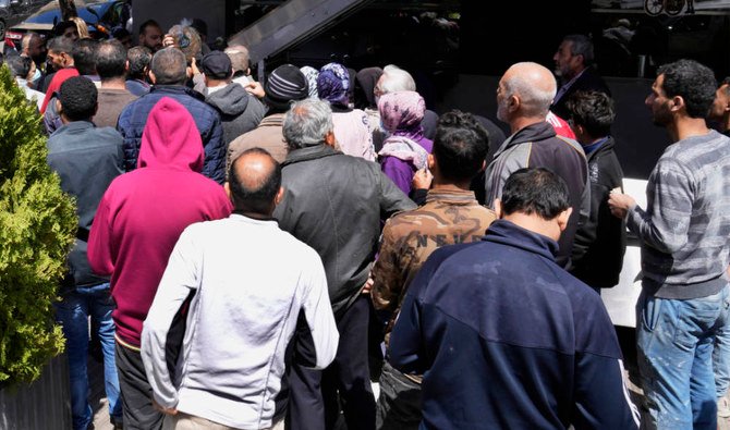 4月12日火曜日、ベイルート南部郊外で、パンをパン屋の前で求めて列を作るレバノン人とシリア人たち。（AP）