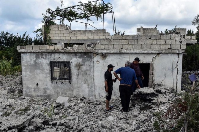 イスラエルが7月上旬に空爆を行った後、シリア西部の港湾都市タルタスにある建物に生じた損害を、住民たちが評価している。イスラエルは今年、シリアの領土を17回攻撃した、と戦争監視団は主張している。(AFP)