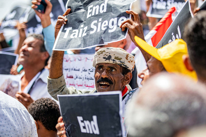イエメンのフーシ派武装勢力による封鎖の解除を求め、「タイズ包囲を終わらせろ」と書かれた紙を掲げるデモ参加者。（ファイル/AFP）