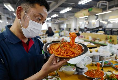 プラスチック製の食品サンプル(完成品)を確認する宮沢宏明工場長。2022年6月17日撮影。神奈川県横浜市の岩崎グループの工場にて。(AFP)
