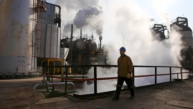 イランの首都テヘラン南部にある製油所で歩くイランの石油労働者。(AP/File)