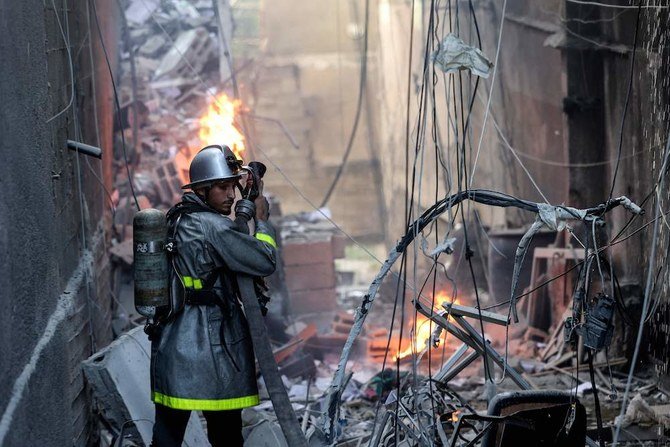 2022年8月5日、イスラエルからガザ市への空爆の後、瓦礫の中で消火作業にあたるパレスチナ人消防士。（AFP）