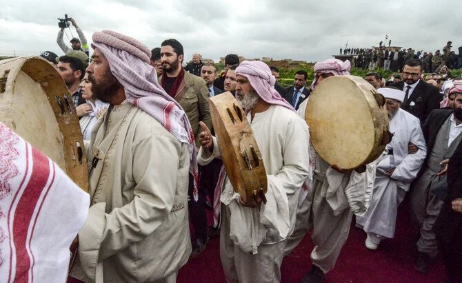 イラクのシンジャール地区コジョ村で、ダーイシュ過激派に殺害された数百人のヤジディ教徒の集団墓を発掘する儀式に参加する、イラク人のヤジディ教徒。（2019年3月15日）（AFP＝時事）