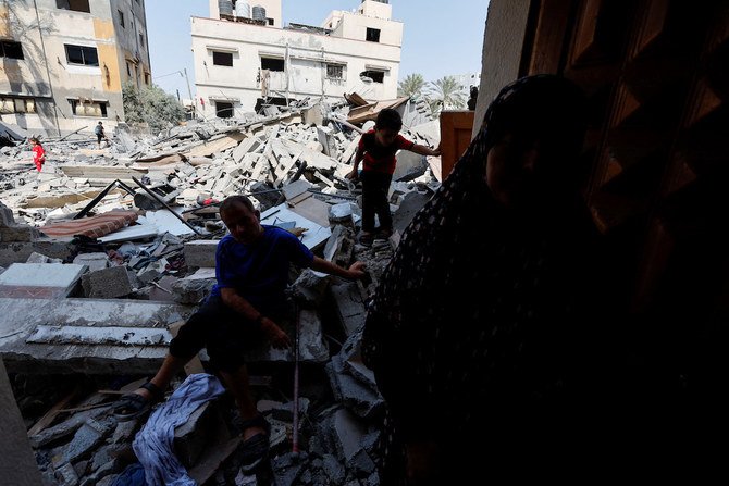 イスラエルとガザ地区の戦闘中にイスラエルの空爆で破壊された自宅の瓦礫の前に座る、パレスチナ人のシャマラク家の障害を持つ4人きょうだいの一人であるであるへシャムさん。2022年8月6日、ガザ市。(ロイター)