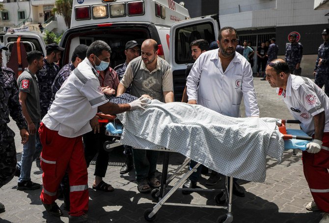 2022年8月6日、ガザ市におけるイスラエルの空爆で負傷したパレスチナ人女性を担架で搬送する救急隊員。（マフムード・ハムス/AFP）