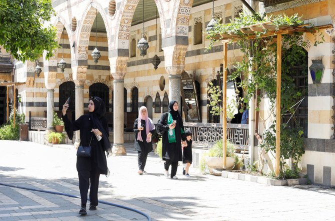 アル・アゼム宮殿で、歩きながら携帯電話を使う訪問者＝2022年7月31日、シリア・ダマスカス。（ロイター）