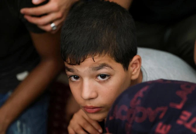 パレスチナ人の10歳の少女、リヤン・アル・シャエルさんの葬儀に参列する幼い少年。少女はイスラエルによる空襲で負った怪我がもとで亡くなった（ガザ地区南部ハーン・ユーニスにて，ロイター）