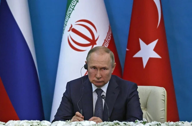 2022年7月19日、テヘランで開催されたイランとトルコとの3者会談後、共同記者会見で両国首脳を見つめるロシアのプーチン大統領。(AFP)