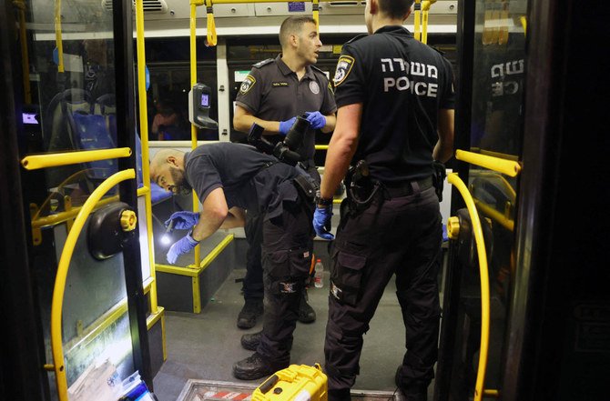 襲撃事件発生後、バスを調査するイスラエルの治安当局。2022年8月14日、エルサレム旧市街の外。（AFP）