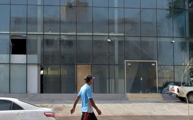 サウジアラビア当局が、アブドゥラー・アル・シェリ容疑者の逮捕時に彼が自爆したと発表した建物のそばを歩く男性と、粉々になった窓ガラス。（AFP）
