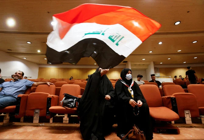 イラクのバグダッドで2022年8月3日、政治危機の中、国会議事堂での座り込みに、イラクの民衆派指導者ムクタダ・アル・サドル氏の支持者が集まり、女性がイラク国旗を手にしている。（ロイター）