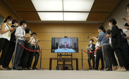 2022年8月22日、共同通信が撮影した写真で、岸田文雄首相は前日に新型コロナ陽性となった後、東京の公邸からリモートの画面で記者の質問に答える。（ロイター経由、共同）