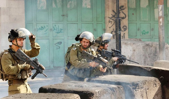 パレスチナ人デモ隊との衝突中、狙いを定めるイスラエル治安部隊。占領下のヨルダン川西岸地区のヘブロン。（AFP）