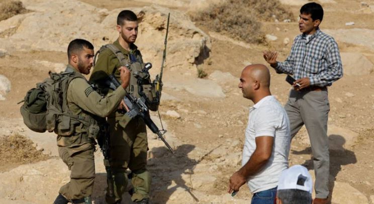 2022年8月29日、イスラエルが占領するヨルダン川西岸地域のヘブロン近郊マサーフェル・ヤッタで、新学期初日にイスラエル陸軍兵士と口論するパレスチナ人の教師。（ロイター）