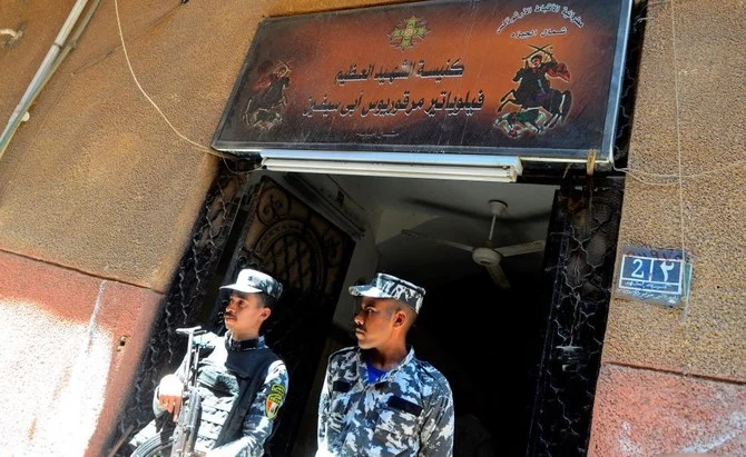 エジプト・カイロ・ギザ県の人口密集地区・インババにあるアブ・セフェイン教会の入口に立つ治安部隊員ら。2022年8月14日日曜日撮影。（AP通信）