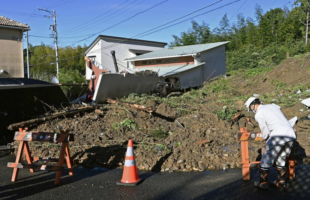 2022年9月24日、日本中部、静岡県浜松市の住宅街に被害をもたらした土砂崩れの現場にて、バリケードを設置する作業員。(ファイル写真/AP)