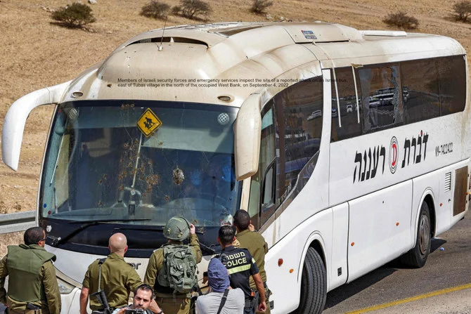占領下にあるヨルダン川西側地区で、イスラエルのバスへの攻撃が報告された現場を査察するイスラエル安全保障部隊員。（AFP通信）