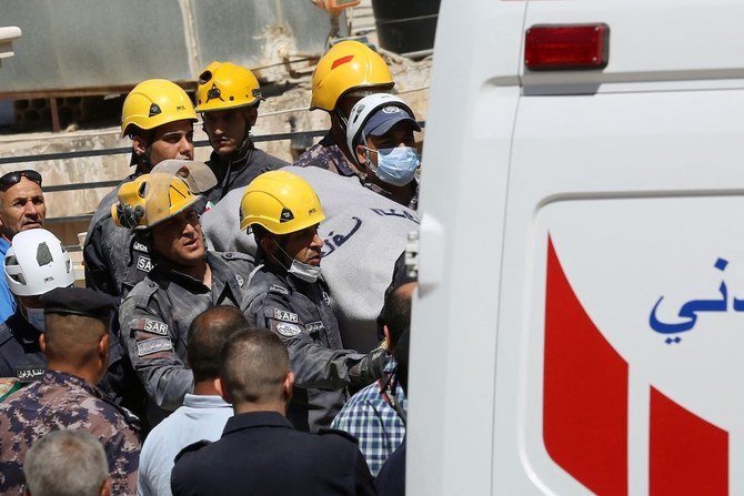 ヨルダンの救助隊員が、倒壊したビルのがれきの中から探し出した遺体を救急車に乗せている。（AFP）