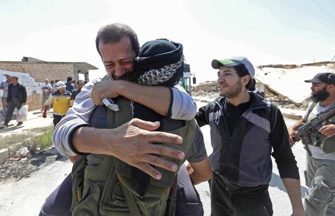 政府の刑務所から解放された被収容者。アレッポ南部のアルエイス交差点に到着した際に、反体制派戦闘員と抱擁する様子＝2018年7月19日（写真：AP通信）