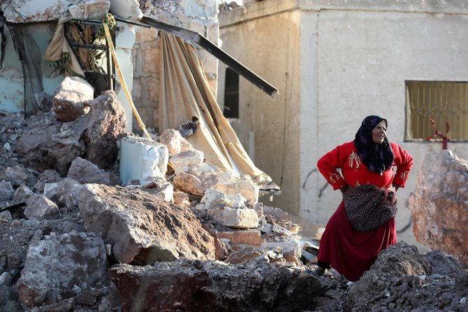 シリア体制の同盟国であるロシアの空爆により破壊されたとされる建物の瓦礫の中で立ち尽くす女性。（ファイル/AFP）